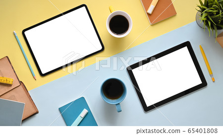 Top view image of colorful working table with accessories putting on it Flat lay two tablet. 65401808