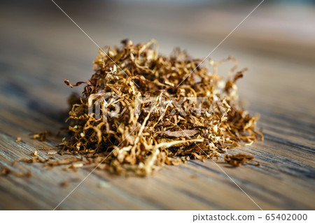 Cut tobacco leaves on the wooden background 65402000