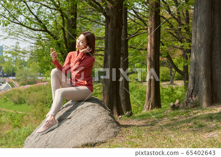 Pretty 20s woman exercising in the park 65402643