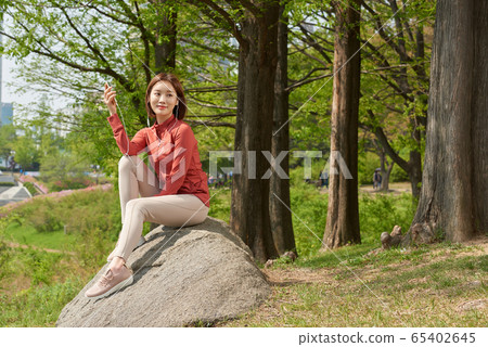 Pretty 20s woman exercising in the park Pretty 20s woman exercising in the park 65402645