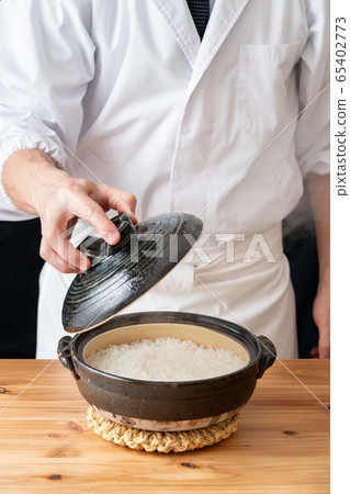 Freshly cooked rice in front of the plate that opens the lid of the clay pot Freshly cooked rice in front of the plate that opens the lid of the clay pot 65402773