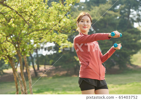 Pretty woman in her 20s exercising in the park 65403752