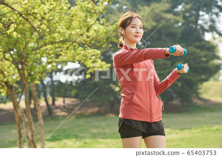Pretty woman in her 20s exercising in the park Pretty woman in her 20s exercising in the park 65403753