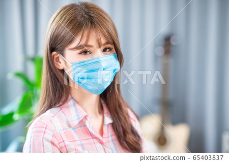 woman self quarantine with mask 65403837