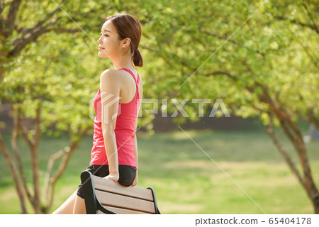 Pretty 20s woman exercising in the park Pretty 20s woman exercising in the park 65404178
