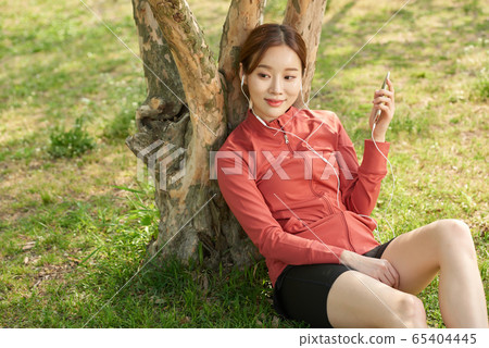 Pretty 20s woman exercising in the park 65404445