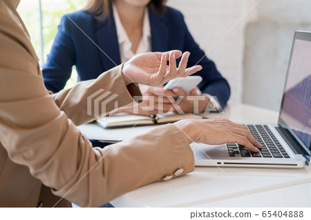 Business team brainstorming and discussing with financial data and report graph. 65404888