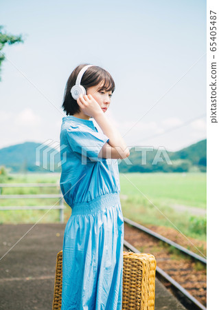 Woman listening to music at the station Woman listening to music at the station 65405487
