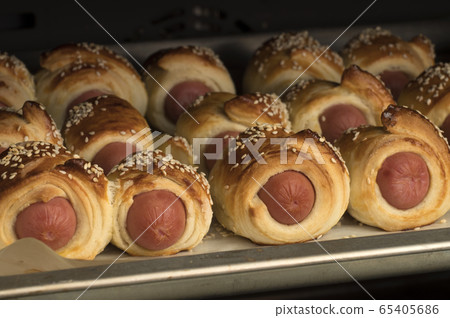 Baked sausages in dough with sesame Baked sausages in dough with sesame 65405686
