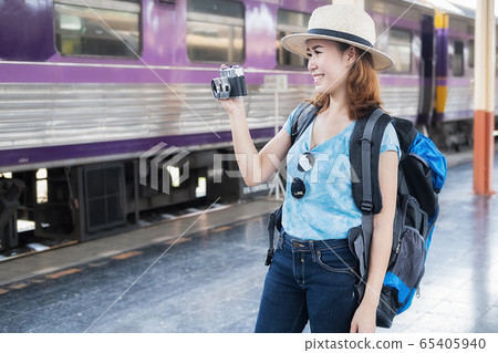Woman traveler tourist with luggage at train station.  65405940