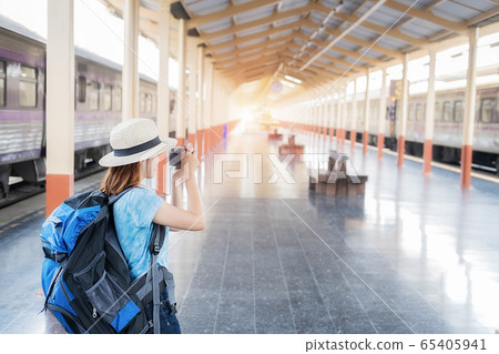 Woman traveler tourist with luggage at train station.  65405941