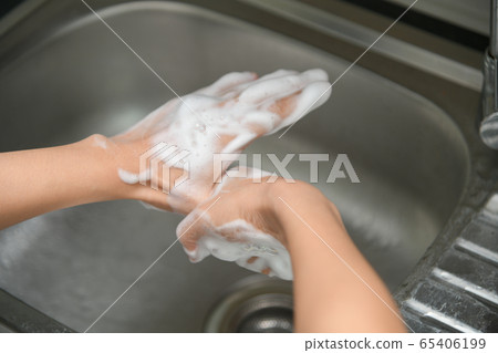 Woman washing hands in a sink with tap water Woman washing hands in a sink with tap water 65406199