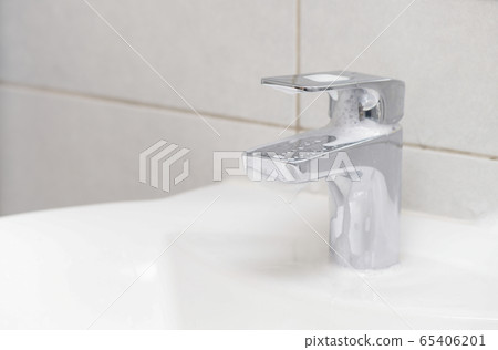 Person or householder cleaning the bathroom sink 65406201