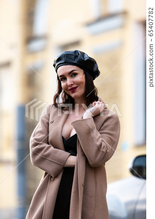 Woman in black pantsuit walks on promenade 65407782