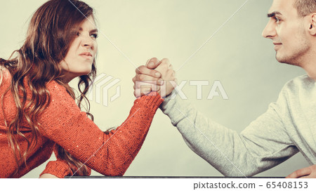 Arm wrestling challenge between young couple Arm wrestling challenge between young couple 65408153