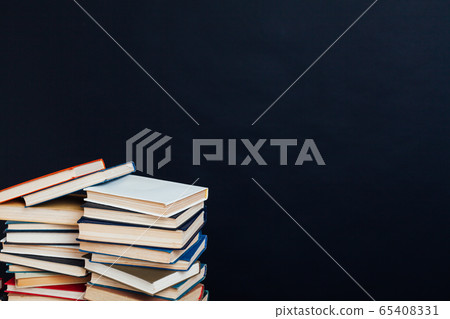 many stacks of educational books to prepare for exams in the university library black background 65408331