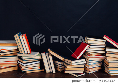 many stacks of educational books to prepare for exams in the university library black background many stacks of educational books to prepare for exams in the university library black background 65408332