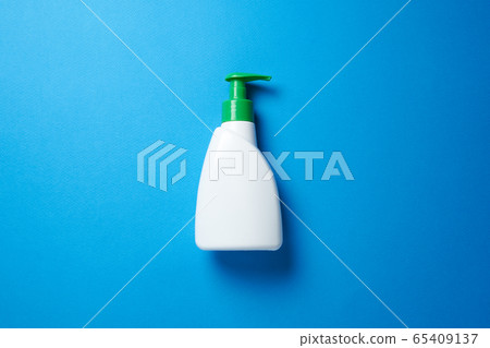 Soap bottle over blue background. Top view flat lay. Soap bottle over blue background. Top view flat lay. 65409137