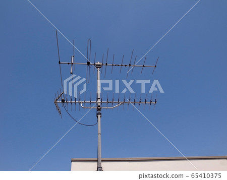 TV antenna (VHF antenna) towering under the blue sky 65410375