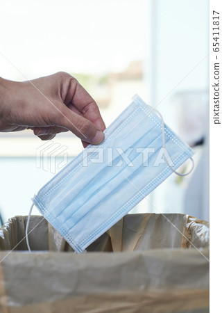 man throwing a surgical mask to the trash can man throwing a surgical mask to the trash can 65411817