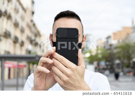 man wearing mask taking selfie or doing video call 65411818