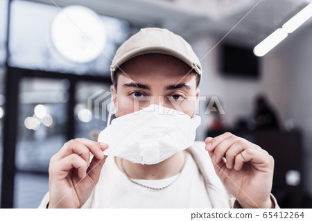 A man puts on a mask from a virus. Flu epidemic. 65412264