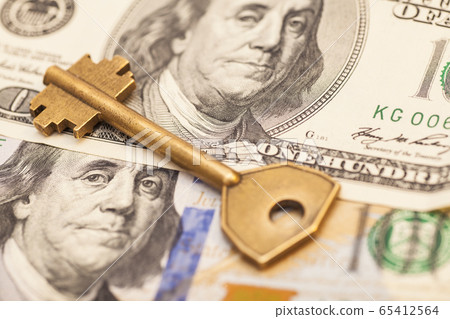 Closeup of key on hundred dollar bills Closeup of key on hundred dollar bills 65412564