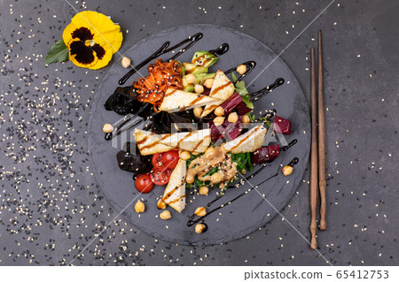 Vegan tofu poke bowls with seaweed, watermelon radish, cucumber, edamame beans and rice noodles. Vegan tofu poke bowls with seaweed, watermelon radish, cucumber, edamame beans and rice noodles. 65412753