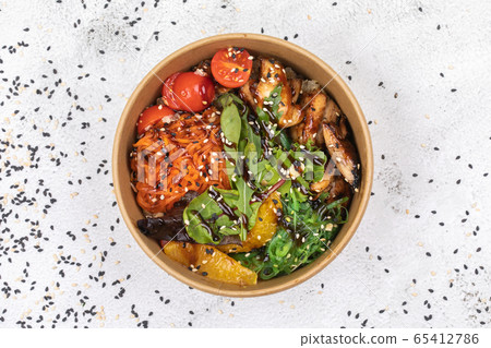 Poke bowl with chicken and vegetables on the white table. 65412786