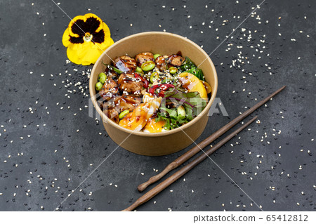 Poke bowl with chicken and vegetables on the white table. 65412812