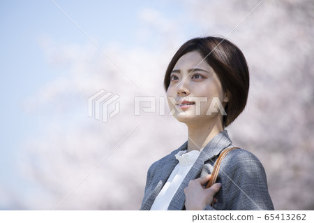 Young business woman in a suit with cherry blossoms 65413262