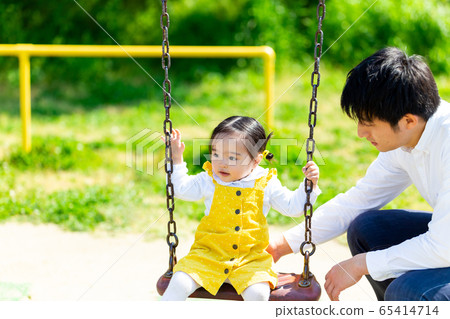 Infant Park Family A cute girl playing with her dad on a swing 65414714