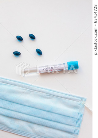 Top view desk in hospital with Coronavirus test tubes with patients blood, pills and respiratory mask. 65414728