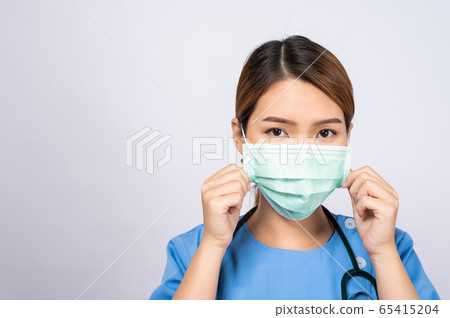 Portrait of young Asian nurse wearing a surgical mask on white background Portrait of young Asian nurse wearing a surgical mask on white background 65415204