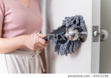 Close up young Asian woman holding dust wiper cleaning house door Close up young Asian woman holding dust wiper cleaning house door 65415299