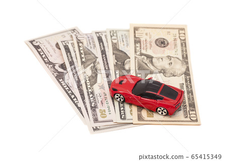 Red toy car on ten dollar banknotes, isolated on 65415349