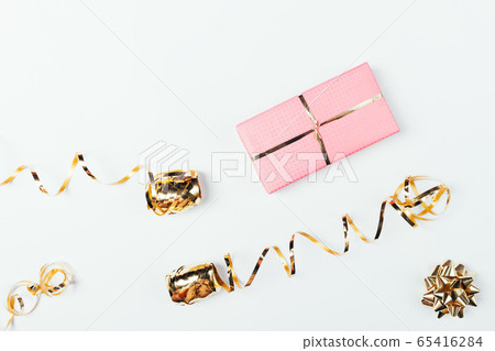 Pink gift box next to golden bow 65416284