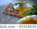 Poached egg on a whole grain bread with arugula  65416638