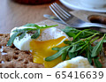 Poached egg on a whole grain bread with arugula 65416639