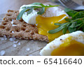 Poached egg on a whole grain bread with arugula  65416640