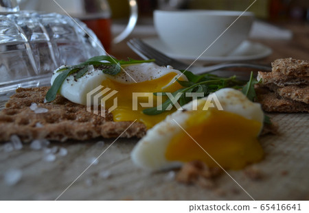 Poached egg on a whole grain bread with arugula Poached egg on a whole grain bread with arugula 65416641