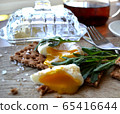 Poached egg on a whole grain bread with arugula  65416644