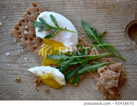 Poached egg on a whole grain bread with arugula on Poached egg on a whole grain bread with arugula on 65416670