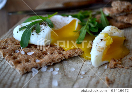 Poached egg on a whole grain bread with arugula on Poached egg on a whole grain bread with arugula on 65416672