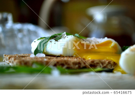Poached egg on a whole grain bread with arugula on Poached egg on a whole grain bread with arugula on 65416675