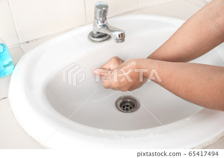 Women wash hands with soap sanitizing hands in the tub with soap, personal hygiene gel 65417494