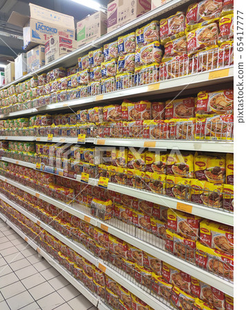 KUALA LUMPUR, MALAYSIA -FEBRUARY 2, 2020: Various brands of instant noodles in a commercial packages stacked for sale on the display shelves in supermarkets.  65417777