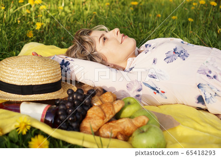 Young girl lying on the plaid. Picnic. Natural light Young girl lying on the plaid. Picnic. Natural light 65418293