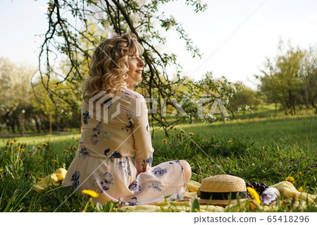 Beautiful woman, weekend out for a walk in a picnic park in the summer garden Beautiful woman, weekend out for a walk in a picnic park in the summer garden 65418296