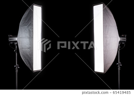 Photo studio lighting stands with flash and softbox isolated on the black. Photo studio lighting stands with flash and softbox isolated on the black. 65419485